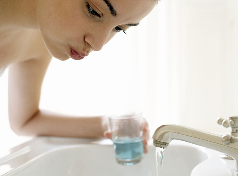 Dùng nước muối loãng để súc miệng nhằm tiêu diệt vi khuẩn gây hại trong khoang miệng